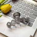 Elegant translucent smoke gray flower hair claw clip with clover cutouts on a laptop - Hollow Flower / 10cm / Gray
