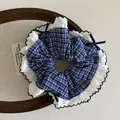 Close-up of navy blue plaid scrunchie with white lace edges and a delicate ribbon bow - 13cm / Large Plaid Navy Blue