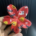 Dettaglio della pinza per capelli a fiore rosso con motivi di zucca e fantasma Halloween - Stile Fiore Elementi Festivi Rosso
