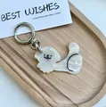 Close-up of a cute white cartoon dog keychain with marble texture on a wooden tray - White Dog