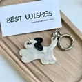 Close-up of cute cartoon dog keychain with marble texture acrylic on wood tray - Jumping Dog (Snoopy Style)