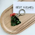 Dettaglio di un pettine natalizio in acetato a forma di albero con fiocco rosso e gancio - Albero di Natale