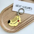 Dettaglio portachiavi giallo a forma di animale con chiusura in argento su vassoio in legno - Banana
