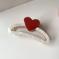 Close-up of pearl white acetate hair claw with a vibrant red heart and golden spring - Red