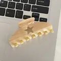 Acetate hair claw clip in creamy marble pattern with star-shaped cutout detail - Champagne Orange Star