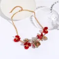 Chic gold chain necklace featuring red and grey acrylic floral pendants on a white plate - Red & Grey