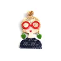 Quirky acrylic brooch featuring a girl with red glasses and blue polka dot outfit - Bun Hairstyle With Green Earrings / Light Coffee and Dark Blue Polka Dot