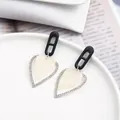 Boucles d'oreilles cœur élégantes avec motif noir ajouré et éclat de nacre - Style Cœur Coquillage Blanc (EH00144)