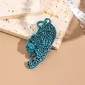 Blue and black acrylic cheetah leopard brooch with spots on elegant stone background - Cyan