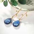Boucles d'oreilles branche dorée avec pendentifs gouttes bleues effet étoilé - Ondulation d'Eau Bleu Profond