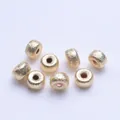 Primer plano de cuentas espaciadoras redondas bañadas en oro 18k con textura cepillada - 4mm / Bañado en Oro de 14K