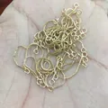 Mano sujetando hilos de pendientes de cadena box de oro de 14k y accesorios de DIY - Cadena de cajitas / Chapado en oro 14K