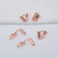 Vista macro de adaptadores de pendientes de clip triangulares bañados en oro de 18k - Rosa oro