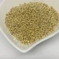 Detailed view of 14k gold-filled crimp beads for DIY jewelry making on white dish - 3.0mm (Approx 30pcs/g) / 14K Gold Plated
