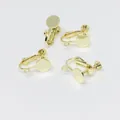 Detail view of four gold-plated screw-back earring converters for DIY jewelry making - With Loop Style / Light gold