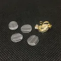 Detalle de almohadillas de silicona y convertidor de pendientes dorado con circonita clara - Almohadilla de pendiente indolora larga