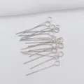 Macro shot of silver metal eye pins for DIY jewelry making on white textured fabric - Platinum Plated