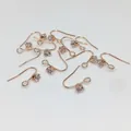 Détails macro des crochets d'oreilles en or rose sertis de zircons ronds étincelants - Rond Or Rose Véritable