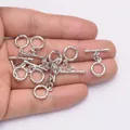 Détail de fermoirs à bascule OT argentés pour bijoux présentés dans la main - Rhodium