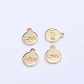 Close-up of four 14k gold-filled round pendants with LOVE engraving for DIY jewelry - Round LOVE / Gold
