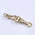 Macro shot of 14k gold lily of the valley hand clasp with green gemstone detail - Gold