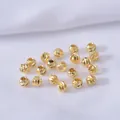 Vue macro détaillée de perles d'espacement dorées avec des motifs en spirale ciselés à la main - 2.5mm / Plaqué Or 18K