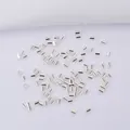 Macro detail of tiny polished silver metal crimp beads for jewelry making projects - 2.0mm / Silver (Color Retention)