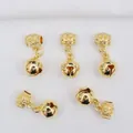 Detail of five 14k gold-filled bell charms with intricate hollow floral carved bail - Bell Style / 14K Gold Plated