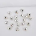 Dettaglio macro di perline a forma di cuore in metallo argentato per creazione gioielli DIY - Argento (Ritenzione del Colore)