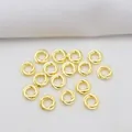 Close-up of 14k gold-filled 4mm twisted ring spacers for DIY jewelry making - 4mm Outer Diameter / 18K Gold Plated