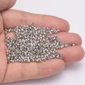 Petites perles métalliques argentées facettées pour bijoux DIY présentées sur la main - Diamètre Extérieur 8mm / Or Rhodié