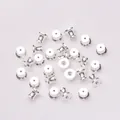 Dettaglio di chiusure per orecchini color argento su uno sfondo di tessuto bianco tramato - Stile Argento Base
