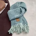 Detailaufnahme des blau-beigen Strickschals mit hochwertigem Lederetikett und Fransen - 180*30cm / Blaugrün