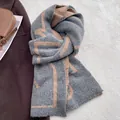 Detalle de una bufanda de punto gruesa con patrón geométrico en gris carbón y camel - Gris Café