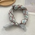 Blue and brown plaid square scarf tied in a knot on a soft minimalist background - Plaid Coffee