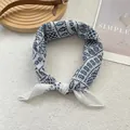 Blue and white patterned square scarf with geometric leaf print styled on grey surface - White Porcelain Pattern