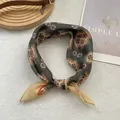 Detail of vintage geometric silk scarf with floral patterns on a white textured backdrop - Ethnic Green