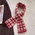Detail of red and white checkered knit scarf with a Hand Made woven label on wool coat - Plaid Style