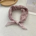 Detail of pink cotton-linen scarf with red geometric and leaf patterns on a textured rug - Coffee Porcelain Pattern