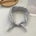 Detail of blue and brown plaid cotton square scarf on soft white textured background - Plaid Blue