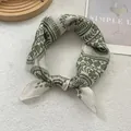 Vue détaillée d'un foulard en soie bohème avec imprimé floral vert sur tissu crème - 58x58 / Vert