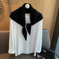 Dettaglio di scialle in maglia di lana nera con bordi ondulati bianchi e fiore di camelia - Solo Scialle / Nero