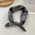 Détail d'un foulard bohème en soie noir et blanc à motif floral sur un fond blanc texturé - 58x58 / Noir