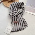 Detailed view of grey and tan striped cotton scarf with leather patch and fashion tag - 180x60cm / Gray