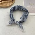 Detailed macro view of vintage blue floral patterns on a white silk scarf with soft lighting - White Garden Floral