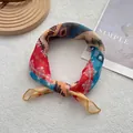 Dettaglio di un foulard in seta colorato con stampa geometrica annodato su sfondo bianco - 58 cm x 58 cm / Giallo