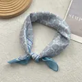 Dettaglio di un foulard quadrato in cotone e lino azzurro con stampa geometrica vintage - Blu