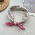 Detailed macro view of pink and green striped satin scarf with glossy silk texture - Pink