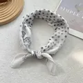 Detailweergave van een witte zijden sjaal met zwarte stippen en paisley-patroon knoop - Zwart