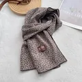 Detailaufnahme des Baumwollschals mit floralem Druck und Markenetikett auf Stoff - 180*60cm / Khaki